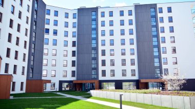 Varşova, Polonya. 17 Nisan 2020. Güneşli bir günde, Bielany bölgesindeki modern apartmanda mavi gökyüzü. Modern bir apartman cephesi.