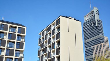 Varşova, Polonya. 19 Nisan 2020. Güneşli bir günde, Wola bölgesinde, gökyüzü mavi olan modern bir apartman. Modern bir apartman cephesi.