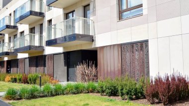 Varşova, Polonya. 20 Nisan 2020. Güneşli bir günde, Srodmiescie bölgesinde, gökyüzü mavi olan modern bir apartman. Modern bir apartman cephesi.