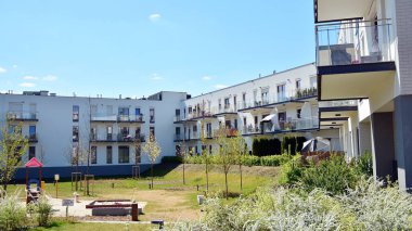 Varşova, Polonya. 27 Nisan 2020. Mokotow bölgesinde, güneşli bir günde mavi gökyüzü olan modern bir apartman. Modern bir apartman cephesi.