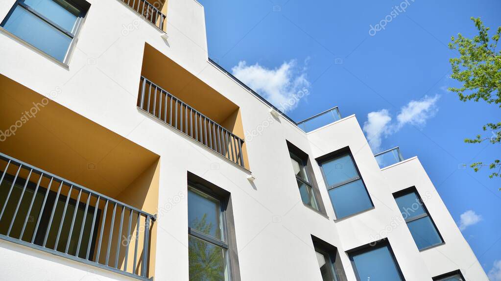 Contemporary residential building exterior in the daylight. Modern apartment buildings on a sunny day with a blue sky. Facade of a modern apartment building