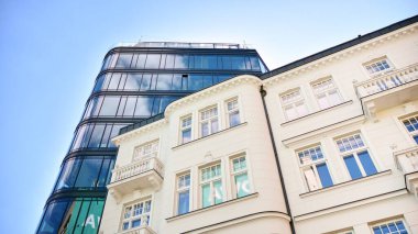 Dikey çizgileri ve yansıması olan modern ofis pencereleri. Gökyüzünü bulutlarla yansıtıyor ve gerçeküstü bir manzara yaratıyor..