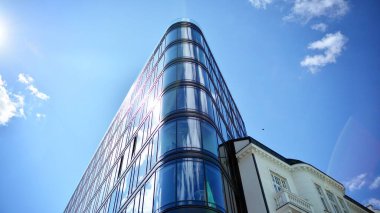 Dikey çizgileri ve yansıması olan modern ofis pencereleri. Gökyüzünü bulutlarla yansıtıyor ve gerçeküstü bir manzara yaratıyor..