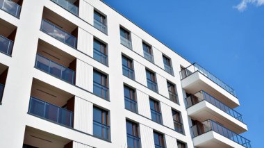 Gökyüzü arka planındaki konut binası. Balkonlu modern bir konut inşaatı cephesi.