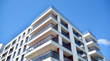 Gökyüzü arka planındaki konut binası. Balkonlu modern bir konut inşaatı cephesi.