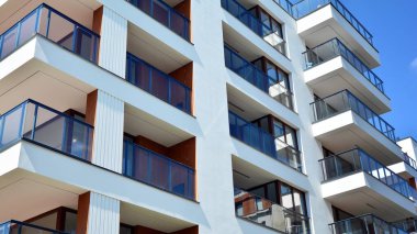 Gökyüzü arka planındaki konut binası. Balkonlu modern bir konut inşaatı cephesi.