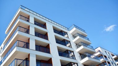 Gökyüzü arka planındaki konut binası. Balkonlu modern bir konut inşaatı cephesi.