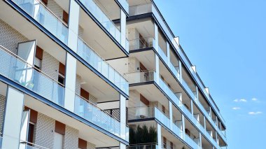 Gökyüzü arka planındaki konut binası. Balkonlu modern bir konut inşaatı cephesi.