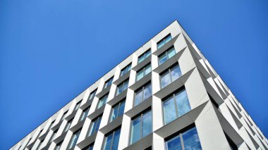 Dikey çizgileri ve yansıması olan modern ofis pencereleri. Gökyüzünü bulutlarla yansıtıyor ve gerçeküstü bir manzara yaratıyor..