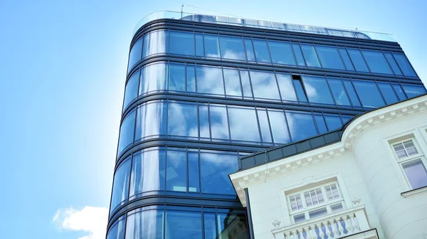 Dikey çizgileri ve yansıması olan modern ofis pencereleri. Gökyüzünü bulutlarla yansıtıyor ve gerçeküstü bir manzara yaratıyor..