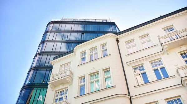 Dikey çizgileri ve yansıması olan modern ofis pencereleri. Gökyüzünü bulutlarla yansıtıyor ve gerçeküstü bir manzara yaratıyor..