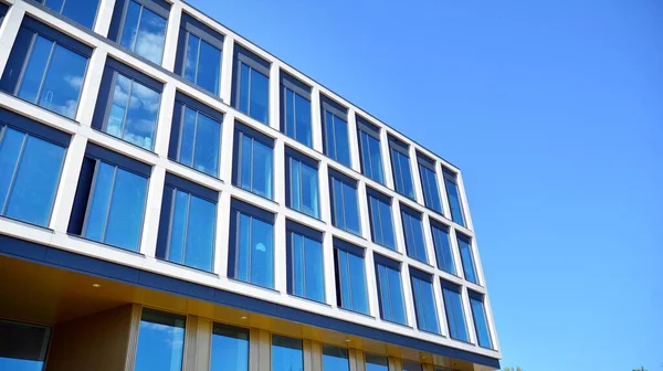 Dikey çizgileri ve yansıması olan modern ofis pencereleri. Gökyüzünü bulutlarla yansıtıyor ve gerçeküstü bir manzara yaratıyor..