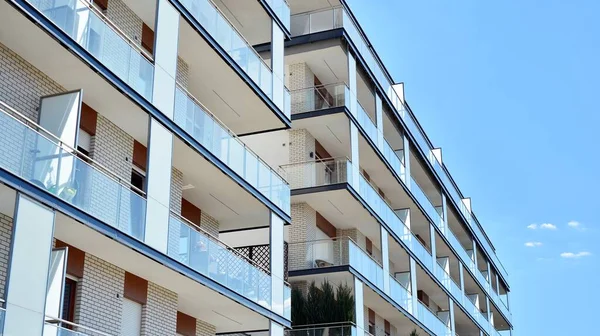 Gökyüzü arka planındaki konut binası. Balkonlu modern bir konut inşaatı cephesi.
