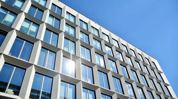 Dikey çizgileri ve yansıması olan modern ofis pencereleri. Gökyüzünü bulutlarla yansıtıyor ve gerçeküstü bir manzara yaratıyor..