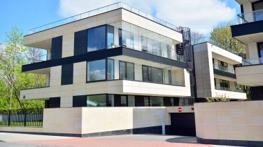 Varşova, Polonya. 30 Nisan 2020. Güneşli bir günde, Bielany bölgesindeki modern apartmanda mavi gökyüzü. Modern bir apartman cephesi.