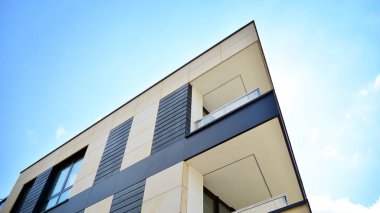 Kocaman pencereleri ve balkonları olan modern bir apartman.