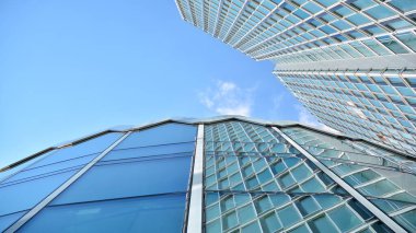 Yapısal cam duvar mavi gökyüzünü yansıtıyor. Soyut modern mimari parçası. Modern cam gökdelen manzarası, modern ofis binası. Modern ofis cephesi mavi camlı.