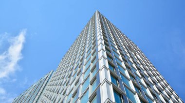 Yapısal cam duvar mavi gökyüzünü yansıtıyor. Soyut modern mimari parçası. Modern cam gökdelen manzarası, modern ofis binası. Modern ofis cephesi mavi camlı.