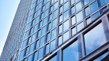 Yapısal cam duvar mavi gökyüzünü yansıtıyor. Soyut modern mimari parçası. Modern cam gökdelen manzarası, modern ofis binası. Modern ofis cephesi mavi camlı.