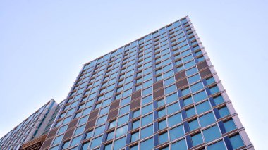 Yapısal cam duvar mavi gökyüzünü yansıtıyor. Soyut modern mimari parçası. Modern cam gökdelen manzarası, modern ofis binası. Modern ofis cephesi mavi camlı.