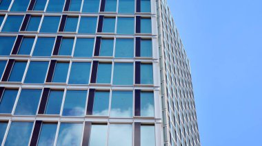 Yapısal cam duvar mavi gökyüzünü yansıtıyor. Soyut modern mimari parçası. Modern cam gökdelen manzarası, modern ofis binası. Modern ofis cephesi mavi camlı.