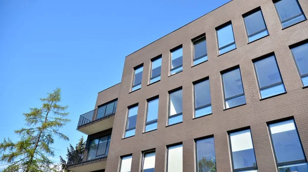 Glass building with blue sky background. Modern office building detail, glass surface clouds reflected in windows of modern office building.