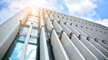 Güneş ışınlı modern mimari. Parlak güneşli bir günde, masmavi gökyüzünde güneş ışınlarıyla cam cephe.