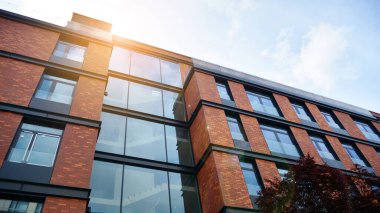 Mavi gökyüzü olan güneşli bir günde modern apartman binaları. Modern bir apartmanın ön cephesi. Güneş ışığıyla yüzeye.