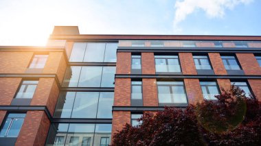 Mavi gökyüzü olan güneşli bir günde modern apartman binaları. Modern bir apartmanın ön cephesi. Güneş ışığıyla yüzeye.