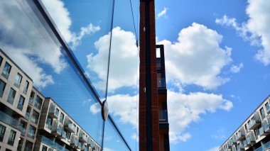 Yapısal cam duvar mavi gökyüzünü yansıtıyor. Soyut modern mimari parçası. Modern cam gökdelen manzarası, modern ofis binası. Modern ofis cephesi mavi camlı.