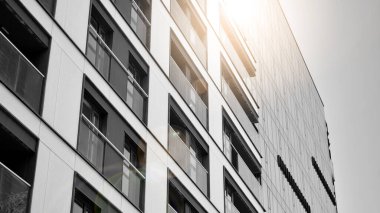 Modern apartman dairesinin dış kısmının ayrıntıları. Yeni lüks ev ve ev kompleksinin bir parçası. Güneş ışığıyla cam yüzey. Siyah ve beyaz.