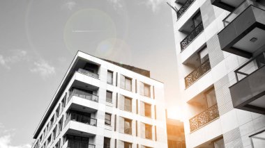 Modern apartman dairesinin dış kısmının ayrıntıları. Yeni lüks ev ve ev kompleksinin bir parçası. Güneş ışığıyla cam yüzey. Siyah ve beyaz.