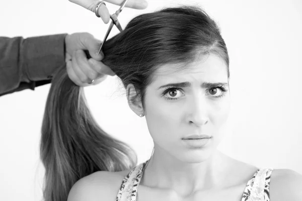 Beautiful woman with very long hair at saloon worried while getting haircut — Stock Photo, Image