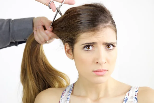 Hermosa mujer joven con el pelo muy largo decepcionado mientras se corta el pelo —  Fotos de Stock