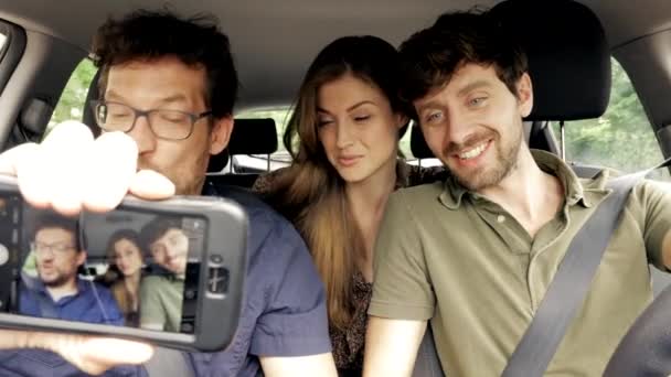 Gente feliz haciendo selfie en el coche mientras conduce — Vídeos de Stock