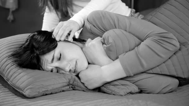 sad woman in bed crying about breakup being comforted by friend