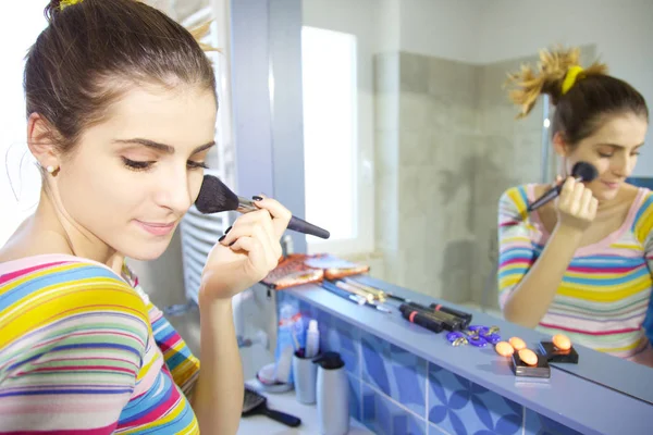 Gelukkig jonge vrouw make-up in de ochtend aanbrengend badkamer — Stockfoto