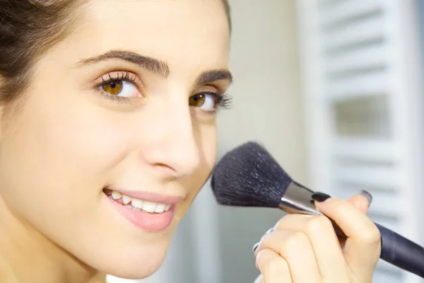 Szczęśliwa młoda kobieta wprowadzenie makijaż rano w łazience zbliżenie — Zdjęcie stockowe