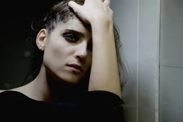 Женщина в отчаянии и печали перед зеркалом в ванной комнате с мокрыми волосами крупным планом — стоковое фото