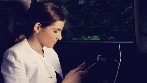 Bella donna sms messaggio con telefono in taxi ad un amico — Video Stock