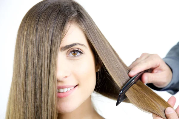 Γυναίκα να πάρει τα μαλλιά βουρτσισμένο με χτένα από επαγγελματία στιλίστα τρίχας ψάχνει closeup της φωτογραφικής μηχανής — Φωτογραφία Αρχείου