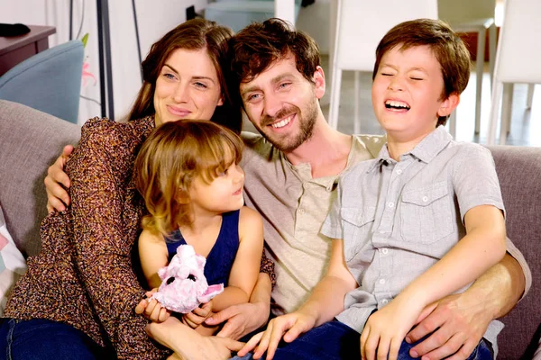 Famiglia felice che ride a casa sul divano — Foto Stock
