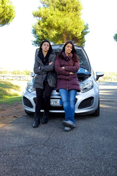 Femmes malheureuses avec assis sur une voiture cassée en attente d'aide plan large — Photo