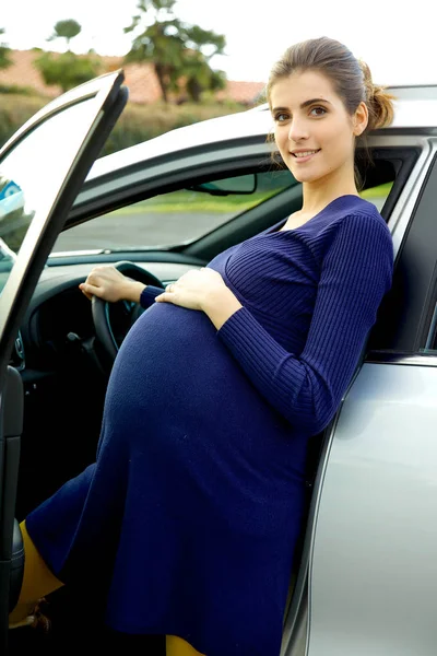 車の前に幸せな笑みを浮かべて妊婦 — ストック写真