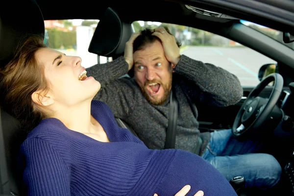 Zwangere vrouw schreeuwen in auto gevoel pijn met schreeuwen man — Stockfoto