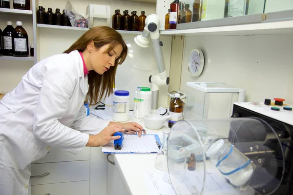 Farmacéutico en laboratorio haciendo papeleo — Foto de Stock