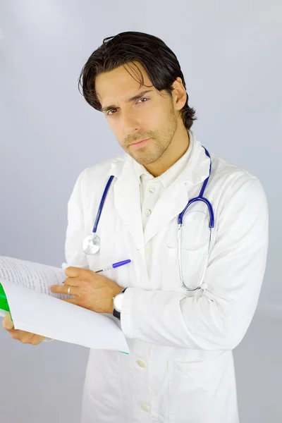 Doctor reading and writing notes on paper — Stock Photo, Image