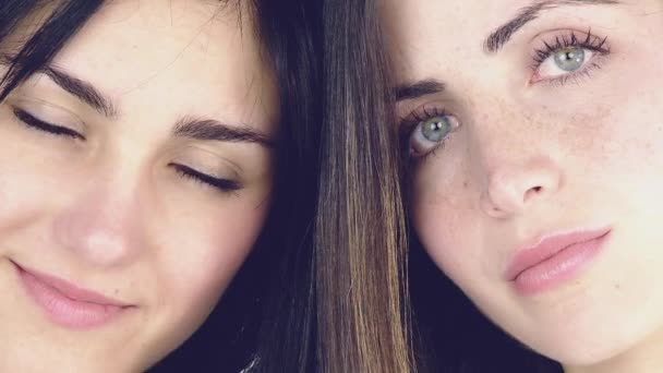 Крупный план двух красивых молодых женщин с зелеными глазами, улыбающихся — стоковое видео