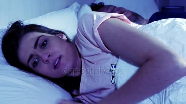 Woman cheating on sleeping husband chatting with lover on cell phone at night — Stock Video