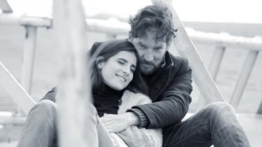 Siyah ve beyaz çift rahatlatıcı ve konuşurken aşık sarıldı